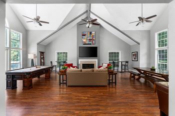 Clubhouse is inviting with a pool table, tv, seating and ceiling fans.